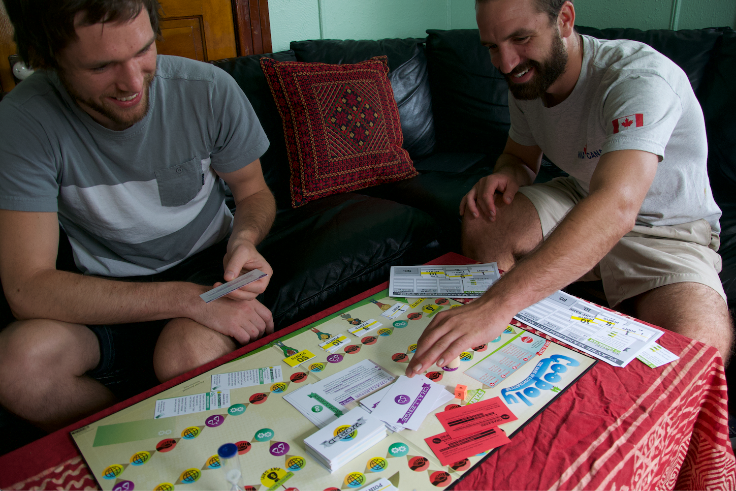 Two men playing a board game on a couch